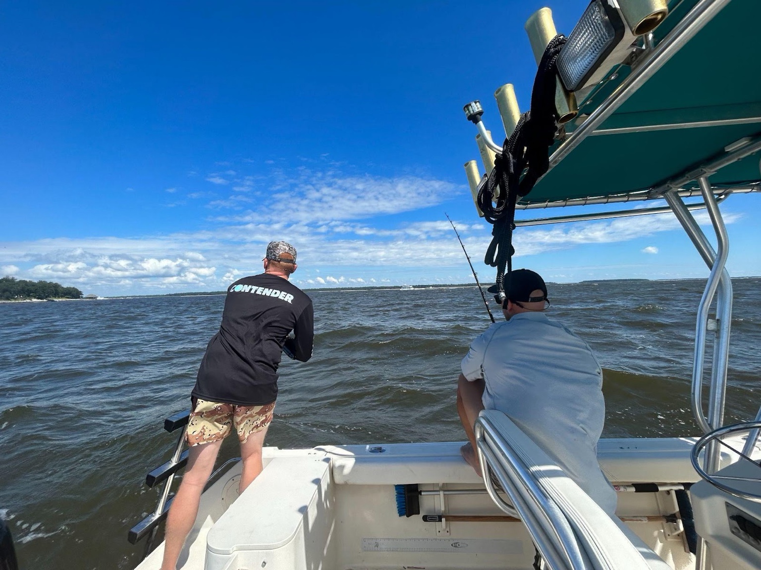 Two anglers fishing from the back of a boat